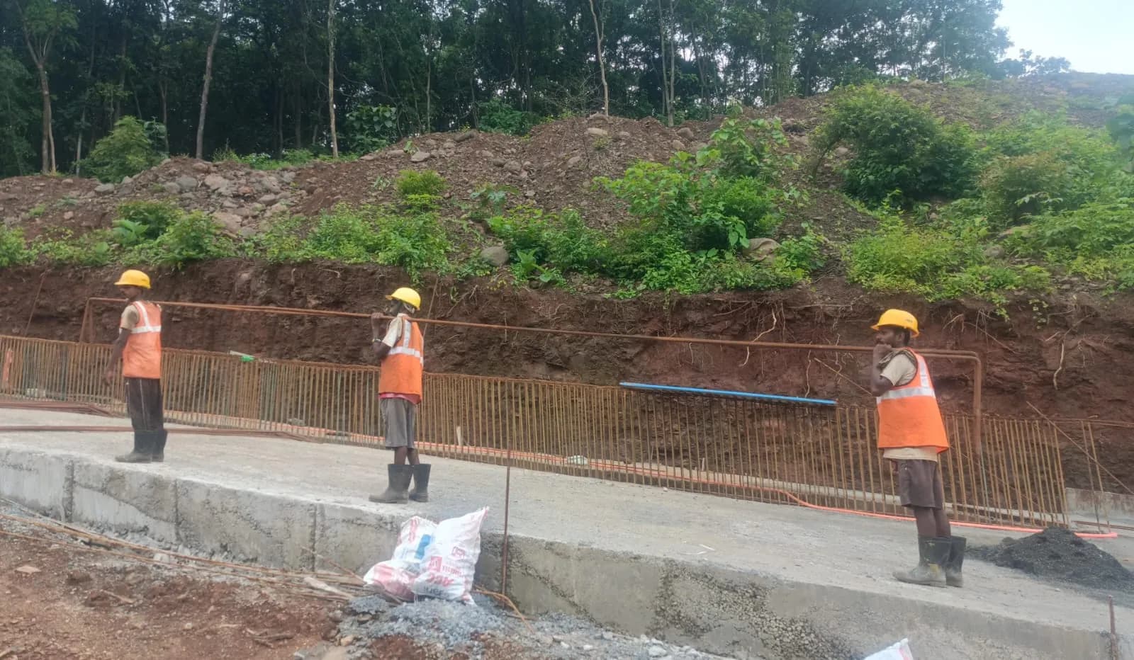 Crew in hard hats and hi-vis working on a hillside slab at Durshet